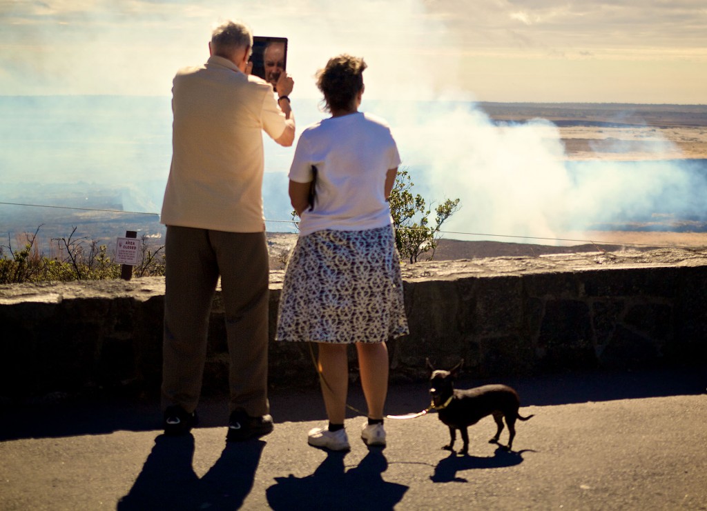 Got a quick snapshot of this couple and their dog visiting Halemaumau, didn't even notice at the time that the guy's face was reflected in his tablet while he shot a photo. The dog appears to be uninterested but then again at his level he can't see anything on the volcano side. Photo by Baron Sekiya